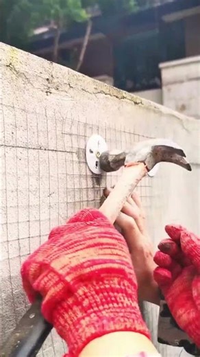 The process of installing wire mesh on a concrete wall using a drill machine #shorts