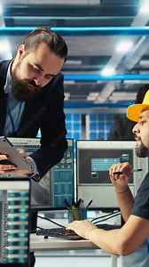 Vertical video Solar panel manufacturing plant expert using tablet to show worker how to use newly developed solar energy systems prototypes. Researcher presents employee new photovoltaics materials