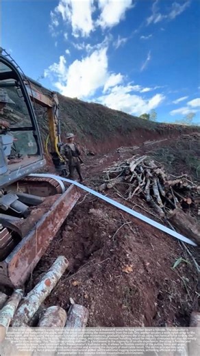 The excavator's belt acted as a makeshift winch, pulling logs down from the hillside.