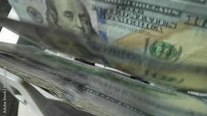 Closeup currency counting machine counting dollar. Slow motion of cash counting machine counts 100 dollar bills USD banknotes. Cash bill counter money machine. Finance banking credit deposit cash.