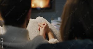 Romantic couple by the Cozy Fireplace. Man and Woman relax by warm fire and warming up their feet. Close up. Winter and Christmas holidays Hygge concept