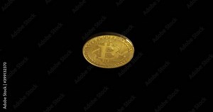 A gold bitcoin coin rotates against a dark background and increases in the frame.