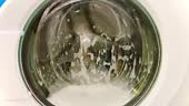 Detergent Bubbles Through the Glass. A close-up view of a washing...