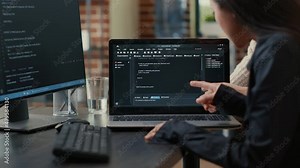 Team of programmers talking about algorithm running on laptop screen pointing at source code while sitting at desk. Software developers collaborating on data coding group project.