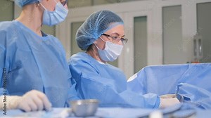 Surgeons perform a complex operation on an elderly woman on the operating table under anesthesia.