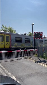 MerseyRail Class 507 passing over a level crossing near Southport