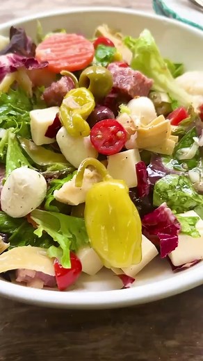 This easy antipasto salad recipe turns a classic antipasto platter into a crowd-pleasing appetizer with a mix of charcuterie, Italian pickles, olives, semi-hard cheese, and a bright and peppery Dijon vinaigrette. | The Mediterranean Dish