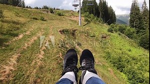 Girl rides or climbs on lift or cable car up mountain.