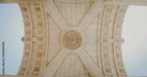 The ceiling of the marble triumphal arch in the classical style. Bottom-up view inside the arch