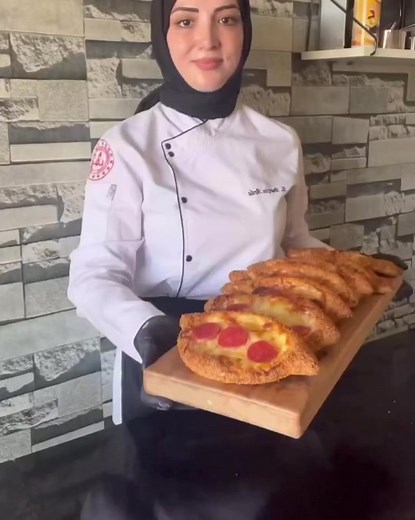 Simit Pizza @chefburcinarda at insta 🇺🇸English/Recipe🇬🇧 Water glass measuring 200ml 500g flour 300 ml water (1.5 cups) 15 ml oil 10g salt (1 teaspoon) 12 g granulated sugar 10 g fresh yeast cheddar cheese sausage Sesame Mix 1/2 cup of molasses with 1 cup of water. Preparation; Bring together all the ingredients required for the dough and make the dough smooth (the dough will be medium hard, neither too hard nor too soft). Divide it into 9 pieces, put a stretch film on it, let it rest for 5 m