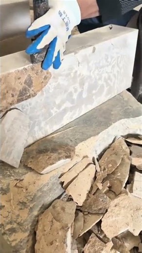 Shaping stone edge carefully using hammer and chisel