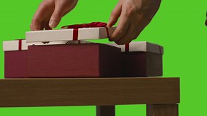 Close Up Of Man Opening Gift Wrapped Present On Table Shot Against Green Screen 1 | Free Stock Video Footage