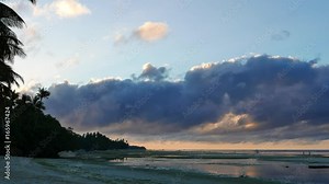 An early morning video from white sand beaches of Siquijor Island, showing low altitude clouds over the beach. Locals can be seen gathering shells from low tide pools. Presented as real time.