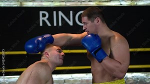 Boxer makes duck defense and knockout punch opponent HD slow motion close-up video. Boxing fight ending: fighter blows to head, falls down in ring