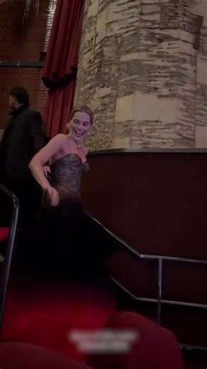Margot Robbie struggling to walk down the stairs in her Schiaparelli gown at the Wuthering Heights LA premiere