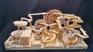 A Wooden Marble Machine That Uses Gears and Lifts to Endlessly Push Marbles Down 3 Separate Tracks