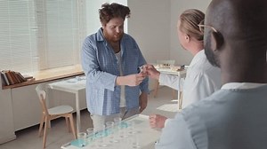 Patients of psychiatric hospital standing in queue taking their medicines, doctor checking their mouths