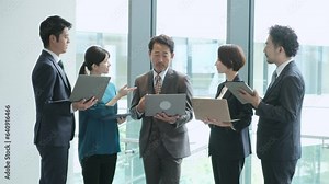 立ってパソコンを使うビジネスパーソン