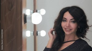Stylish young woman with beautiful professional hair styling posing looking at the camera in a beauty salon. camera movement up