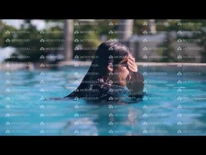 Young asian girl diving underwater and swimming in pool in tropics on vacations.