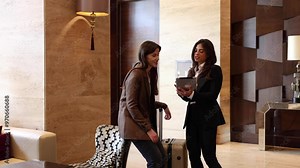 Two businesswomen meet in the lobby for a quick business chat