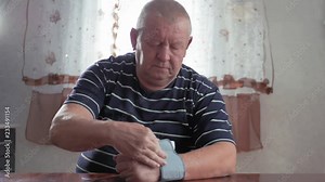Senior man taking his blood pressure at home on the table. Men health check blood pressure.and heart rate with digital pressure gauge standard blood pressure test results .Health and Medical concept.