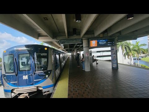 Miami Metrorail Northbound Green Line train arriving and departing at Dadeland North Station.