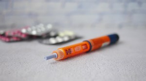 Download Insulin pens and blister pack on wooden background, close up for free
