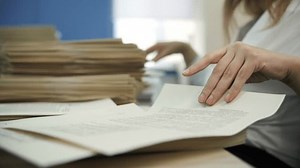 Office Worker Sorting Paper Documents