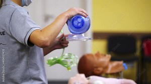 Medic is using CPR technique on dummy in first aid class. Oxigen mask on medical doll demonstration. Training video courses.