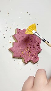 Grace Gaylord on Instagram: "Y’all know I’m a big fan of the parchment paper technique, and when I saw others use it on just half the cookie I knew I needed to use it on this maple leaf! I liked the addition of the splatter because I felt like it helped to bring the whole design together. Also, I’ve decided all of the maple leaves need two names because everyone is just coming up with too good names!! The “Autumn Crush” comes from @jadero27 and the Maple Crunch is from me lol…I like that one is 