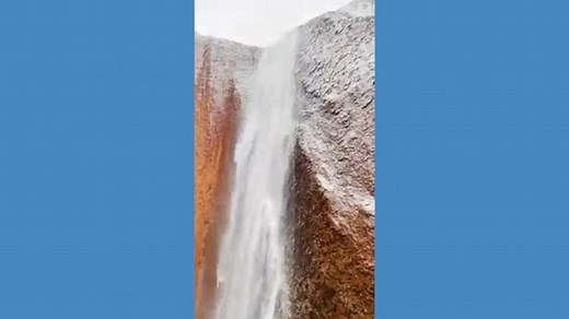 Water seen pouring down off Uluru