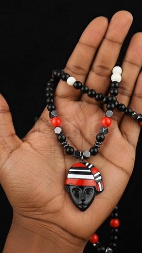 🔥 Command Presence with Bold Elegance 🔥 Step into sophistication with this exclusive handcrafted necklace, featuring bold black beads accented with regal red and ivory details—centered by a striking mask pendant crowned with the iconic red-and-white cap of heritage. 🌍 Why This Masterpiece Stands Out ✔️ Premium craftsmanship designed for distinction ✔️ A perfect blend of tradition and modern luxury ✔️ Bold colors that demand attention wherever you go ✔️ Limited-edition piece, crafted for the c