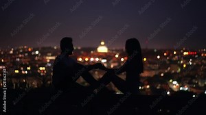 The couple sit on the background of a starry sky. Tender,sweet kiss between man and woman at night time. Italy, Rome night.