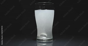 Tablet falling in water and dissolving in slow motion