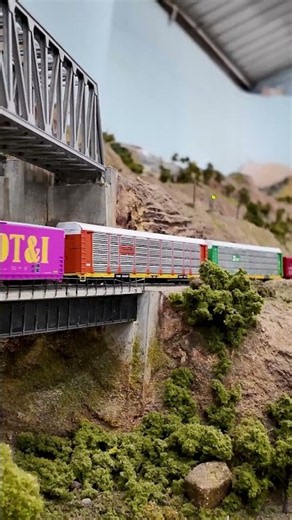 A colorful BNSF freight train crosses the low bridge on our N scale layout