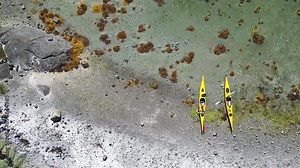 Kayaks on shore, beach, in Norway, Scandinavia with beautiful Norway natural landscape in the north, Norland, Hamaroy area. Kayaking in Nordic countries
