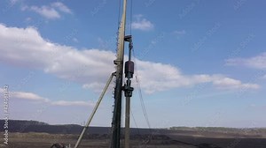 Excavation at a construction site, diesel pile driving machine with rumble and smoke drives piles deep into the ground to ensure the strength of the foundation of the future structure