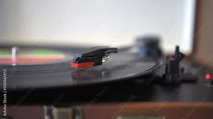 Vinyl record player with turntable in a modern design. Retro audio equipment. Sound technology sound reproduction using new technologies on an old record. black vinyl record is spinning on turntable.