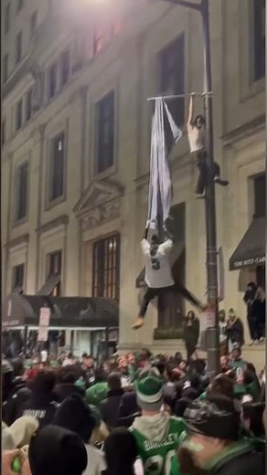 Eagles fan falls from pole after hanging on flag that rips off during celebration