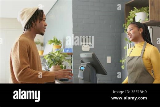 African American male customer greeting cashier at cafe counter placing coffee order on touchscreen. Cafeteria, professionalism, contemporary, service, interaction, collaboration, decor Stock Video Footage - Alamy