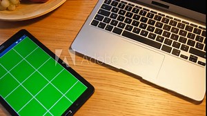 A modern workspace featuring a laptop and a tablet elegantly positioned on a wooden table