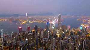 Time lapse day to night high view of Hong Kong skyline cityscape over Victoria harbour at Victoria Peak