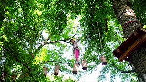 Toddler kindergarten. Little girl playing on the playground. Little girl climbing on high rope park. Little girl having fun at adventure park.