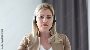 Young woman wears headset conference calling on laptop talks with online teacher studying, working from home. Lady student e learning using computer webcam chat makes notes. Distance education concept