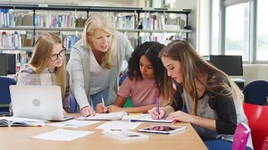 Premium stock video - Tutor working with female college students in library