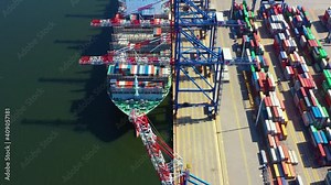 Container ship loading at port with crane, container ship carrying container import and export business logistic and transportation, Aerial top view.