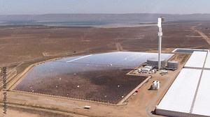 Solar thermal power plant which uses mirrors to heat salt in the tower. Molten salt is used to generate steam power. Green renewable energy and global warming concepts.