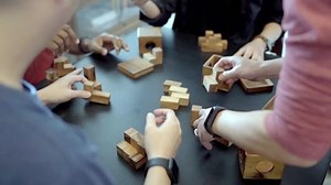 Team work, team building exercise. Puzzle made out of cubes, team of men trying to put together a puzzle. Solution. Game, activity.