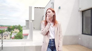 young caucasian woman standing on the terrace of a modern office or balcony at home and smokes marijuana. Business lady smoking cannabis. female relieves stress at work a light drug. businesswoman
